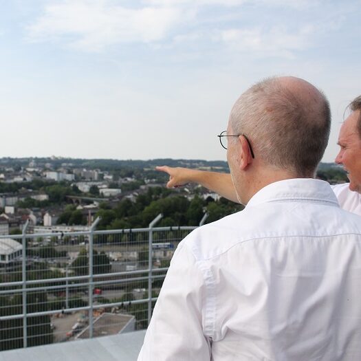 Zwei Männer blicken vom Gaskessel auf die Stadt.