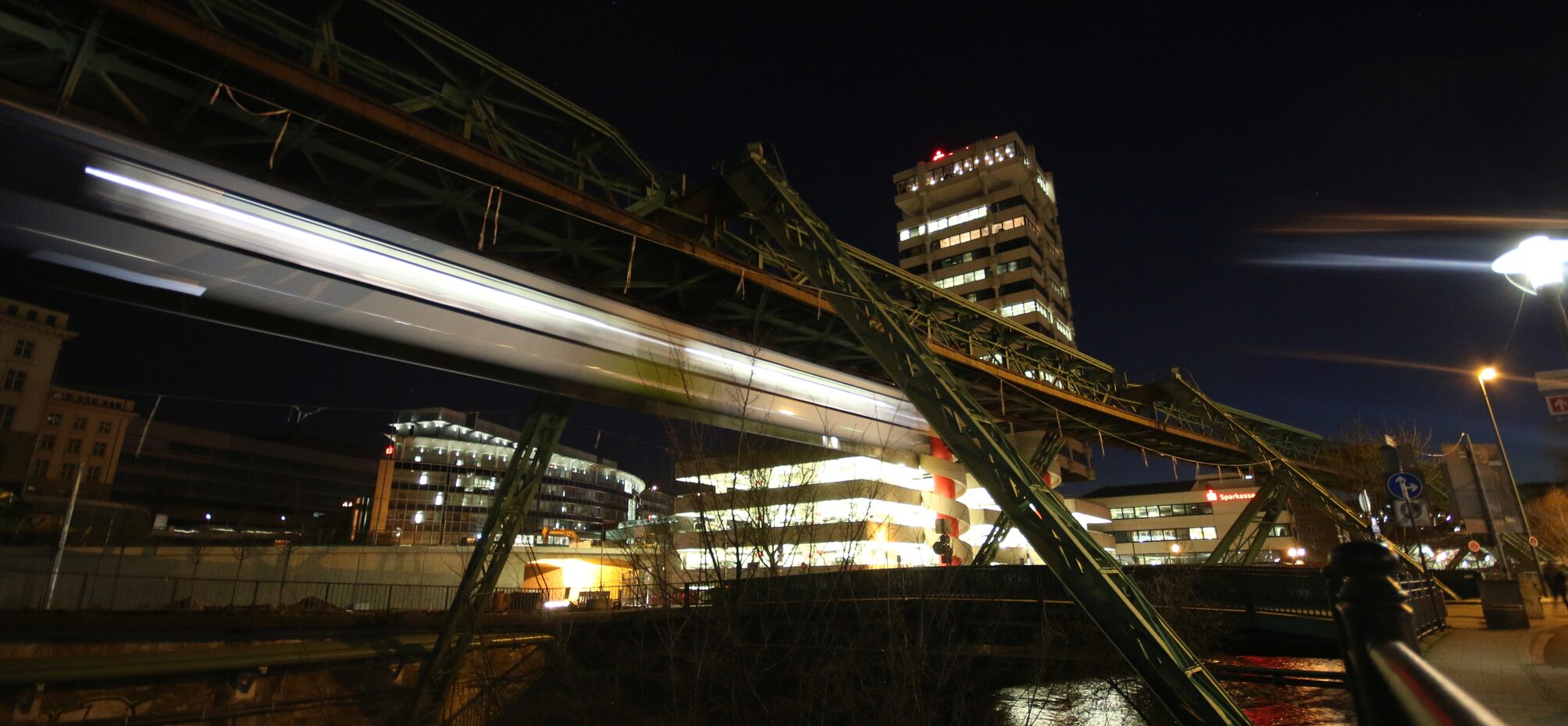Die Lichter der Schwebebahn und des Sparkassenturms bei Nacht.